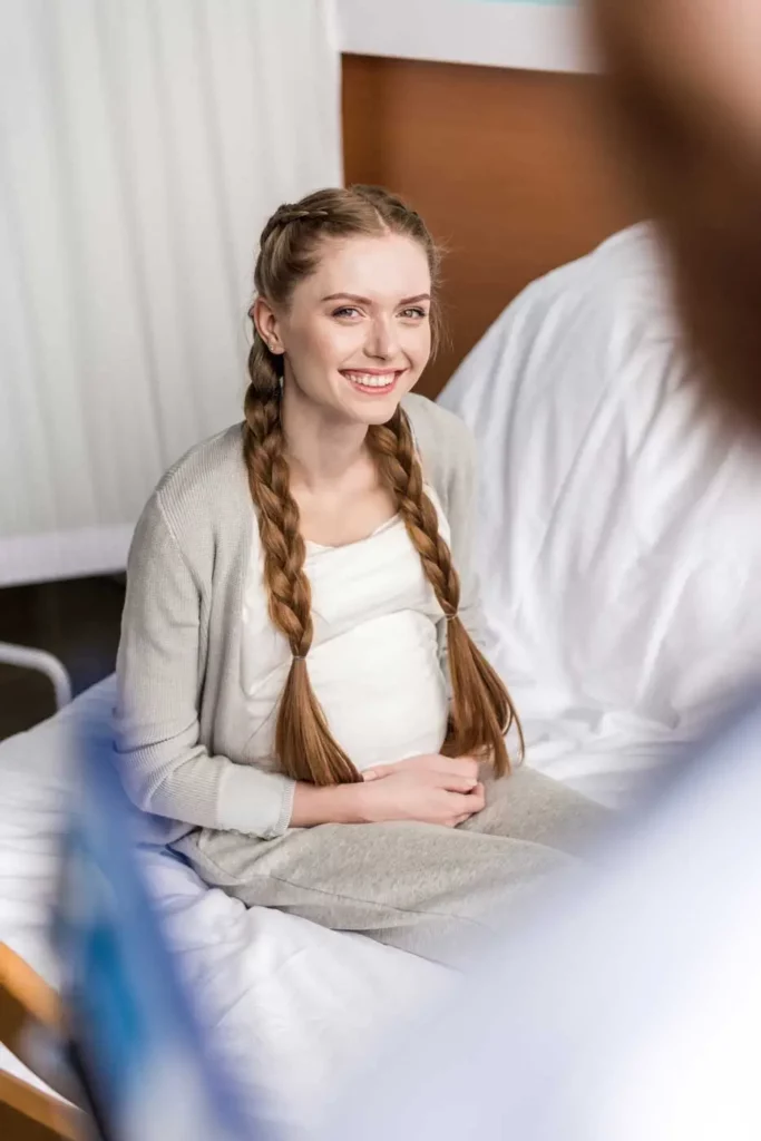 smiling pregnant young woman sitting on hospital b 2023 11 27 04 55 09 utc